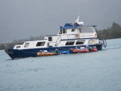 PUMA II WITH SKIFFS AND RIVER BOATS IN TOW