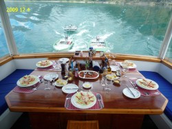 PUMA II DINING AREA SET WITH KING CRAB APPETIZERS -- NOTE THE SKIFFS BEING TOWED BEHIND